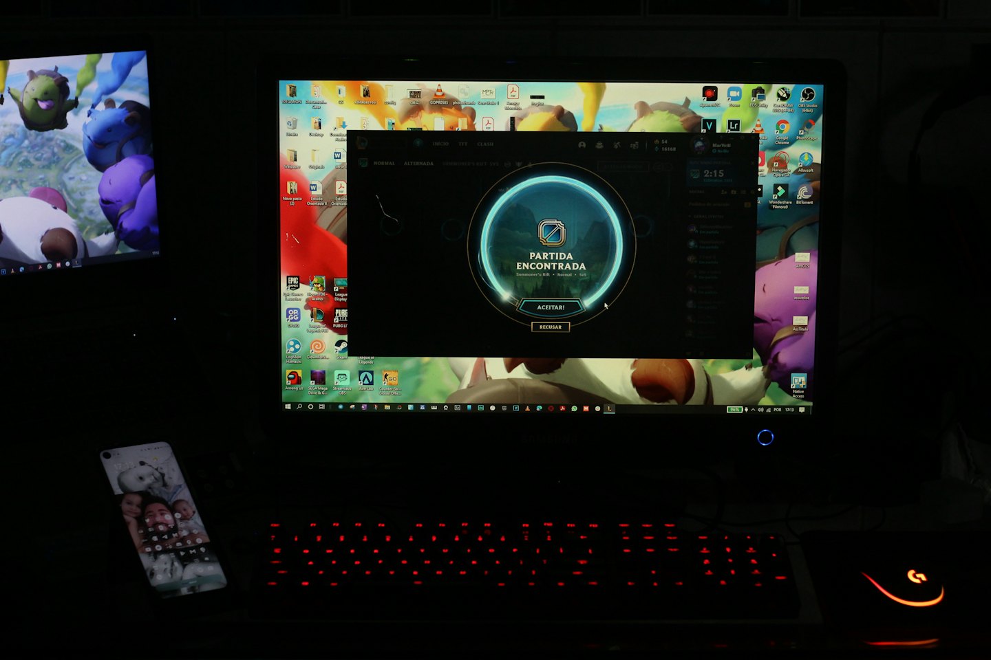 Configuration de jeu avec deux moniteurs, un clavier et un smartphone.