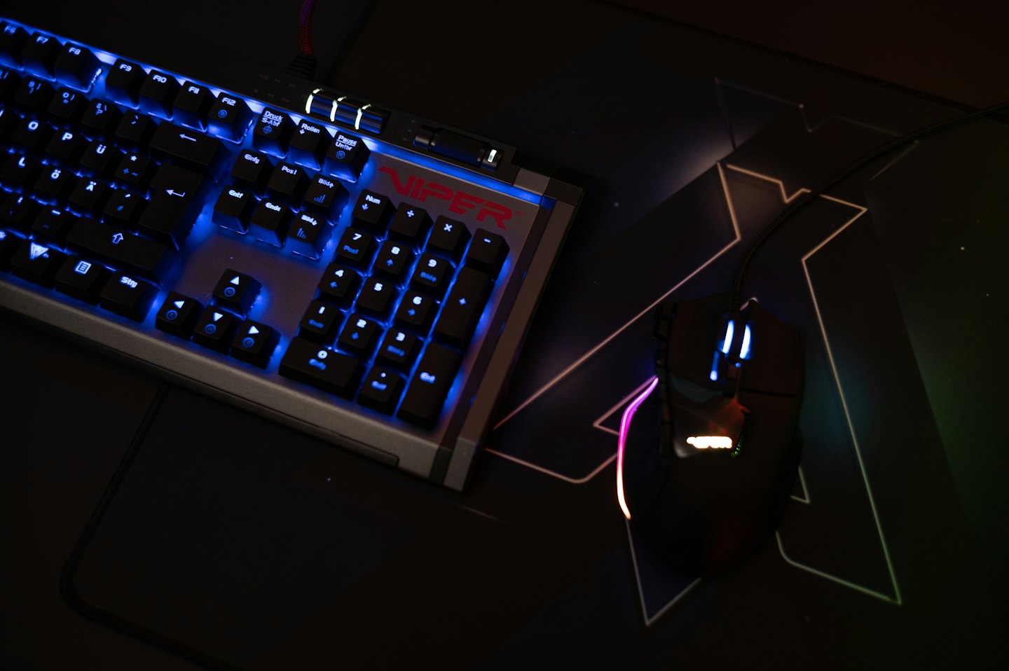 Un clavier et une souris de jeu avec rétroéclairage bleu et rose.